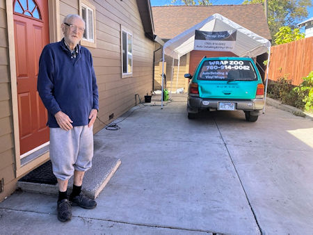 Don in front of house and Andrew's business Wrap Zoo