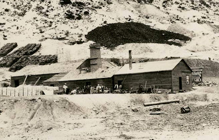 Rare photo of the Belshaw smelter. Note the stack of bullion bars (front left of the smelter). It is difficult to believe this shabby looking smelter was capable of producing silver bullion at a faster rate than had ever been recorded in the United states. The building may have given the appearance of being in disrepair, but Belshaw's blast furnaces were at the cutting edge of silver smelting, and could produce 5.25 tones of bullion in 24 hours. The large dark area directly above the furnace stack is not smoke, but most likely, the huge surface pit (outcrooppng) of the Union Chimney, an excptionally rich deposit of galena (silver/lead) that ran 15-70 feet wide and 760 feet deep.