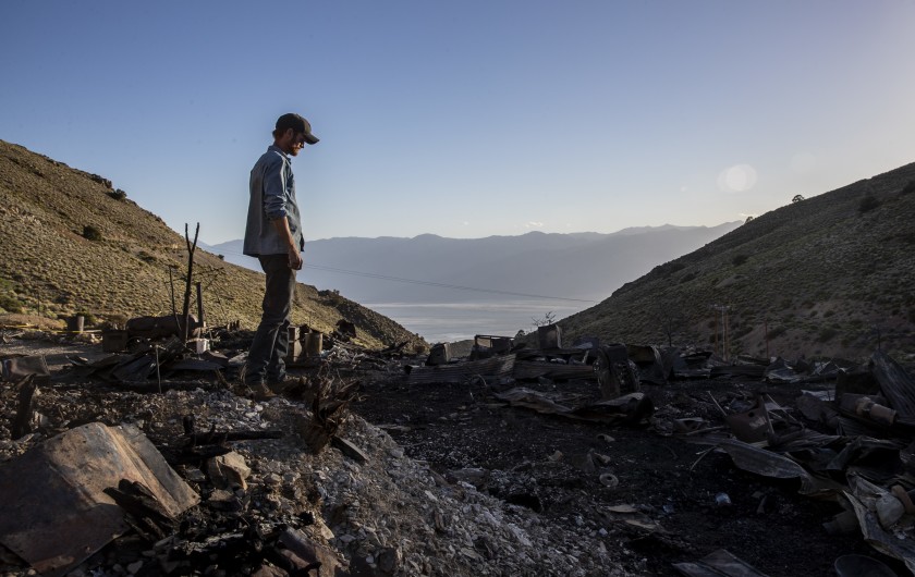 Brent Underwood stands amid the mountainside ashes of the American Hotel at Cerro Gordo, far above the desert below.
