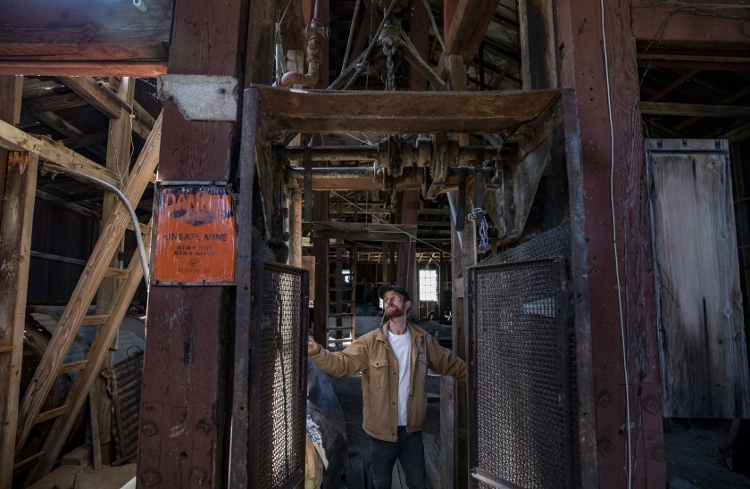 Brett Underwood stands between massive wooden posts of the headframe of the Union Mine in Cerro Gordo ghost town Brett Underwood stands between massive wooden posts of the headframe of the Union Mine in Cerro Gordo ghost town