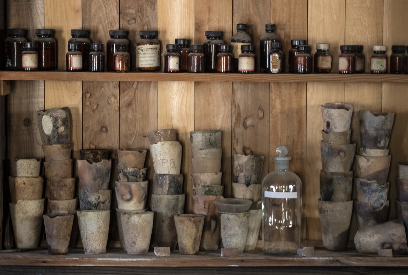 Vintage chemical jars and crucibles on a shelf at the Cerro Gordo ghost town in the Inyo Mountains