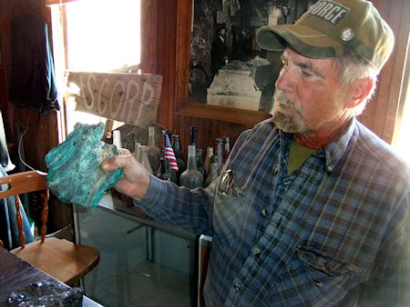 Robert Desmarais, the caretaker/historian at Cerro Gordo and a retired schoolteacher, displays a pig of silver and lead that was smelted by the early Mexican miners prior to the introduction of steam power and the construction of a modern furnace