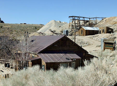 Back side of the Belshaw House, built in 1868 by Mortimer Belshaw in the Cerro Gordo mining camp. Seen at top are the tailings and tramway associated with the Union Mine. Below it is the assay office. To the right of it are the remaining cribs from Lola's brothel