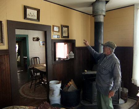 Cerro Gordo's resident caretaker/historian Robert Desmarais points to a drawing in the anteroom of the Belshaw House, built in 1868 by Mortimer Belshaw in the mining camp