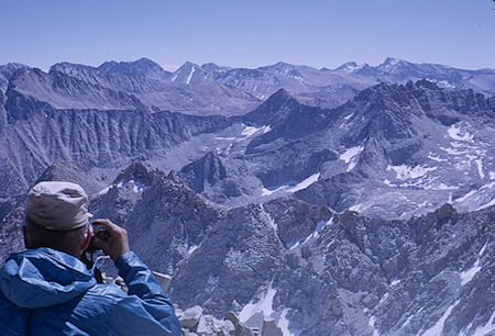 Bill Paine photographing view southeast toward Mt. Whitney (right skyline) from Mt. Brewer - Kings Canyon National Park 27 Aug 1963