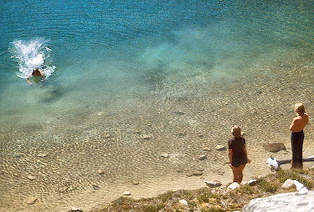 Lisa Sternberg and Randy Stevenson watching Marty Nikolaus swim in Lower Mill Creek Lake<br>John Muir Wilderness 02 Sep 1976 Lisa Sternberg and Randy Stevenson watching Marty Nikolaus swim in Lower Mill Creek Lake<br>John Muir Wilderness 02 Sep 1976