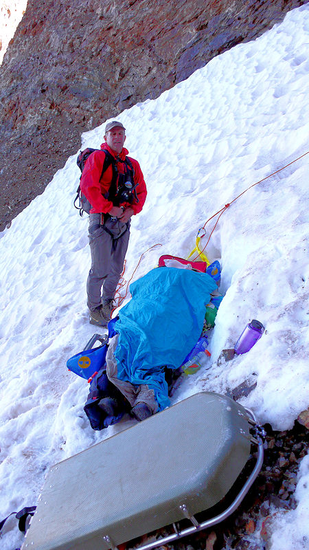 The injured hiker is stabilized on the 40 degree slope, while other team members set up anchors to begin the 1800 foot lowering down the slope