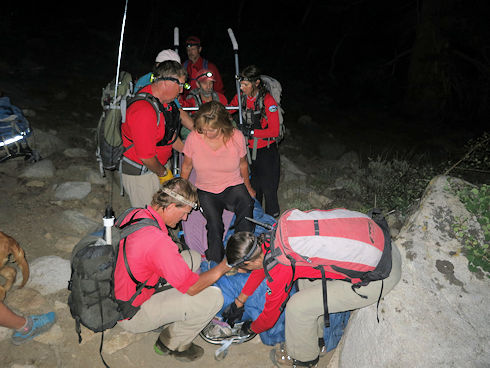 Settling the injured hiker into the wheeled litter